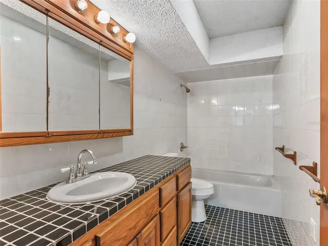 an empty room with chandelier fan and windows