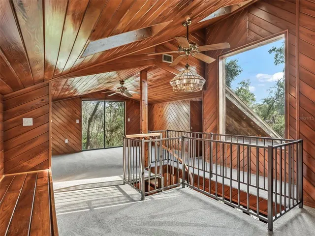 a view of a room with a ceiling fan and window