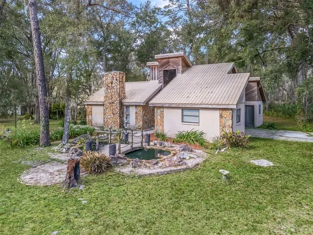 a aerial view of a house with table and chairs in a yard