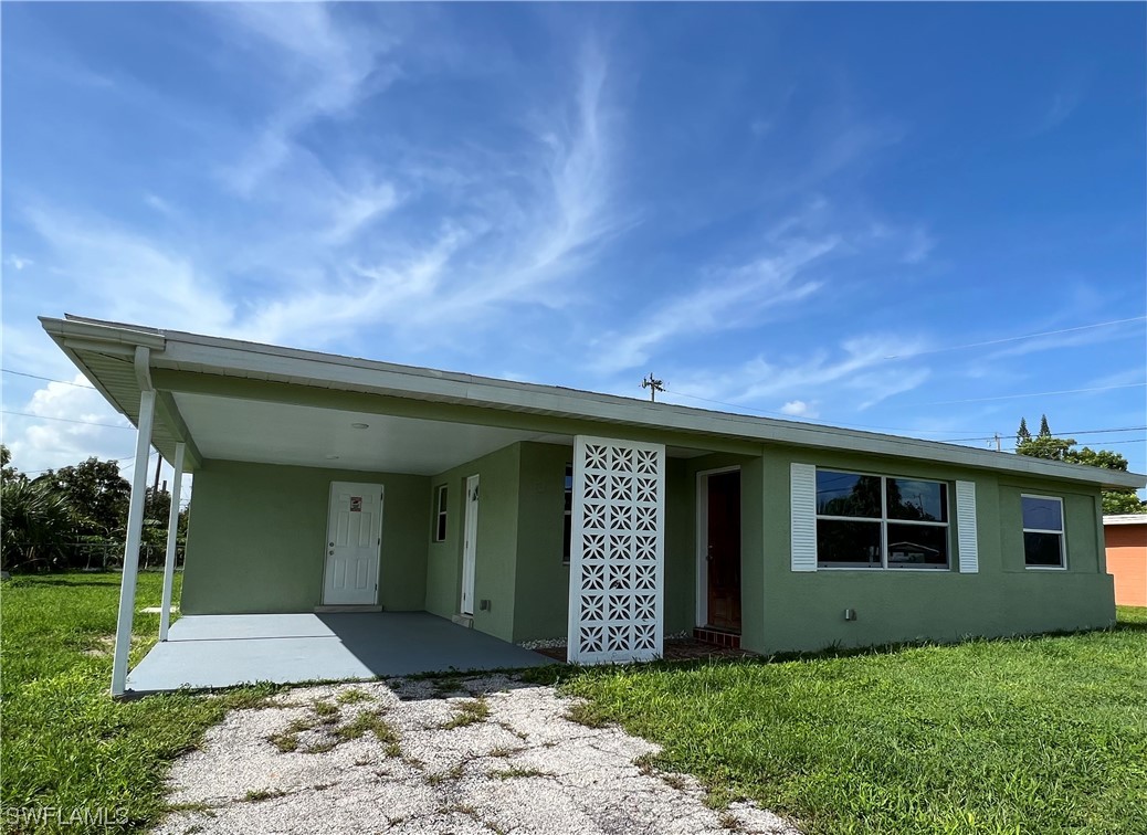 513 Wyoming Road Lehigh Acres, FL 33936 - Photo 1 of 30 a front view of a house with a yard