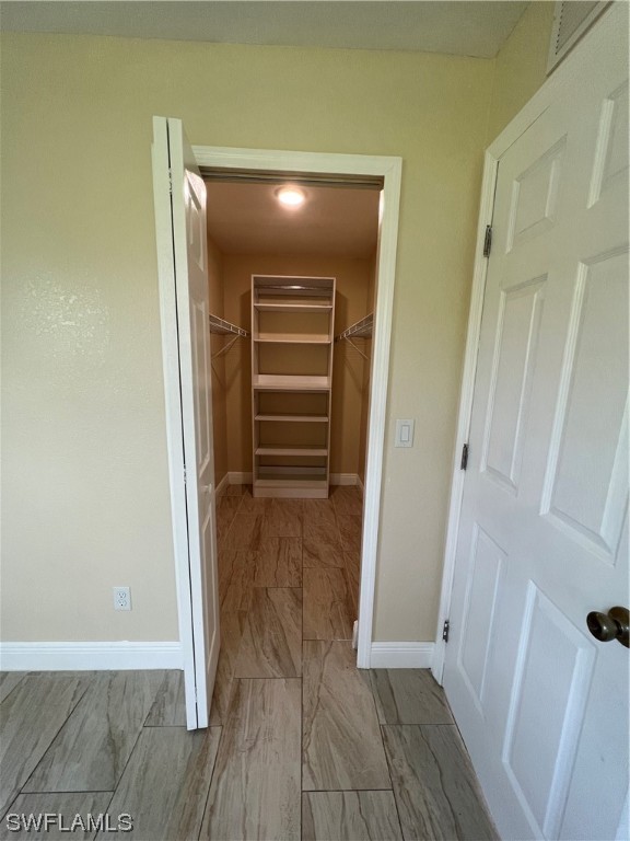 513 Wyoming Road Lehigh Acres, FL 33936 - Photo 21 of 30 a view of walk in closet with wooden floor