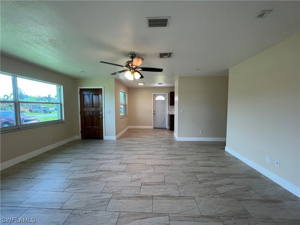 513 Wyoming Road Lehigh Acres, FL 33936 - Photo 5 of 30 a view of an empty room with window and chandelier fan