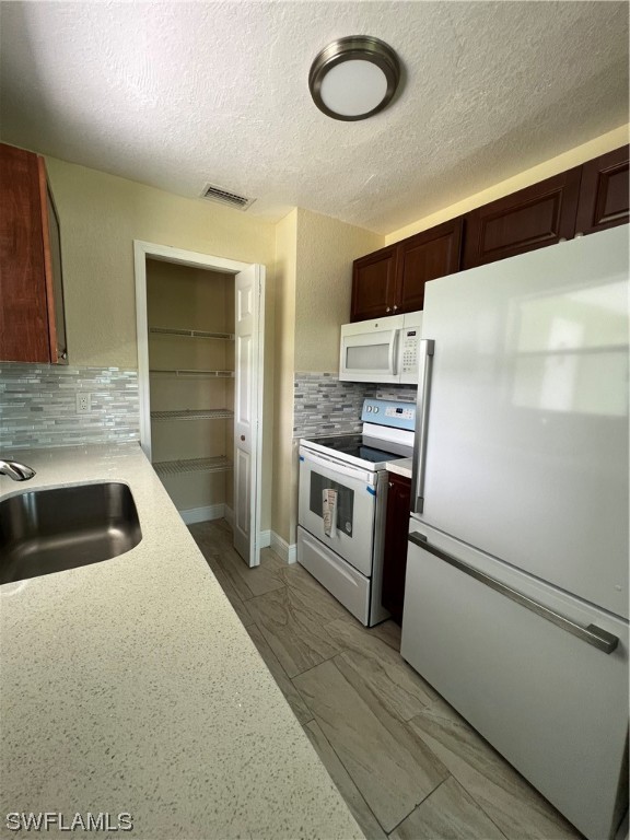 513 Wyoming Road Lehigh Acres, FL 33936 - Photo 10 of 30 a kitchen with a refrigerator sink and stove