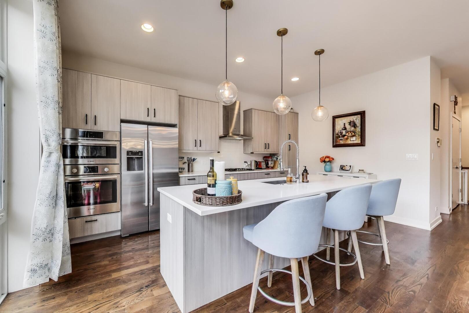 1832 West Rice Street, Unit 1N Chicago, IL 60622 - Photo 2 of 28 a kitchen with stainless steel appliances a dining table chairs and wooden floor