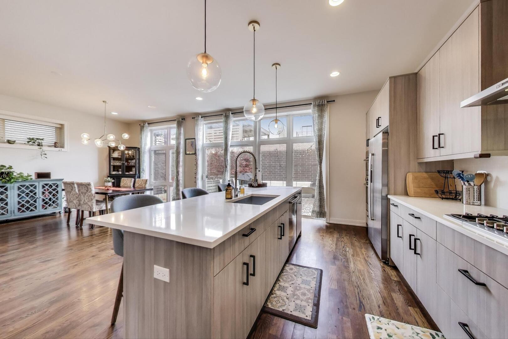 1832 West Rice Street, Unit 1N Chicago, IL 60622 - Photo 3 of 28 a kitchen with stainless steel appliances granite countertop a sink stove and wooden floor