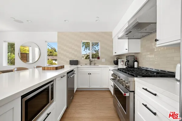 a kitchen with stainless steel appliances granite countertop a sink stove and cabinets