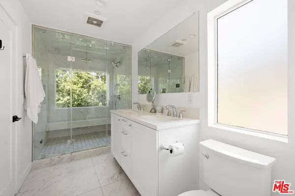 a bathroom with a granite countertop sink toilet and shower