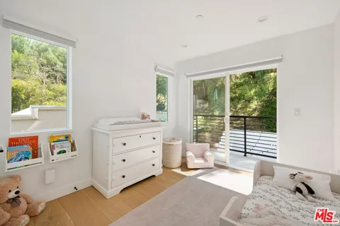 a bedroom with furniture and a large window