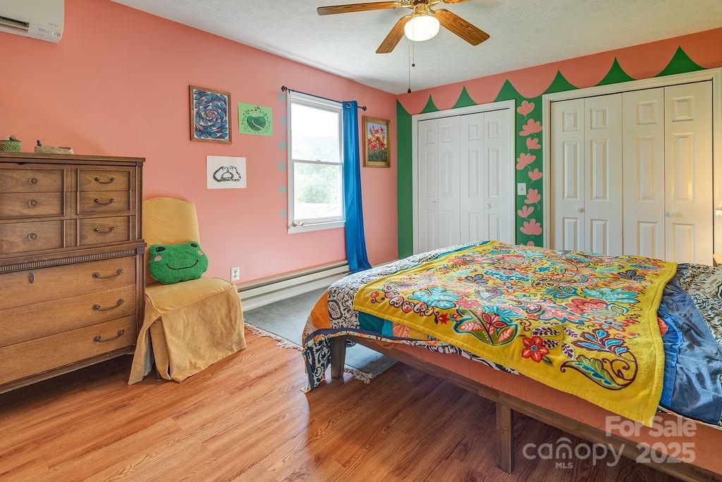 124 Beaverdam Loop Road Candler, NC 28715 - Photo 14 of 31 a bedroom with a bed and a dresser