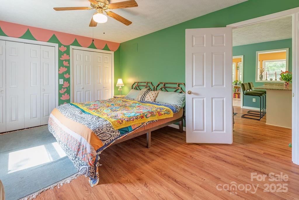124 Beaverdam Loop Road Candler, NC 28715 - Photo 15 of 31 a bedroom with a bed and a chandelier