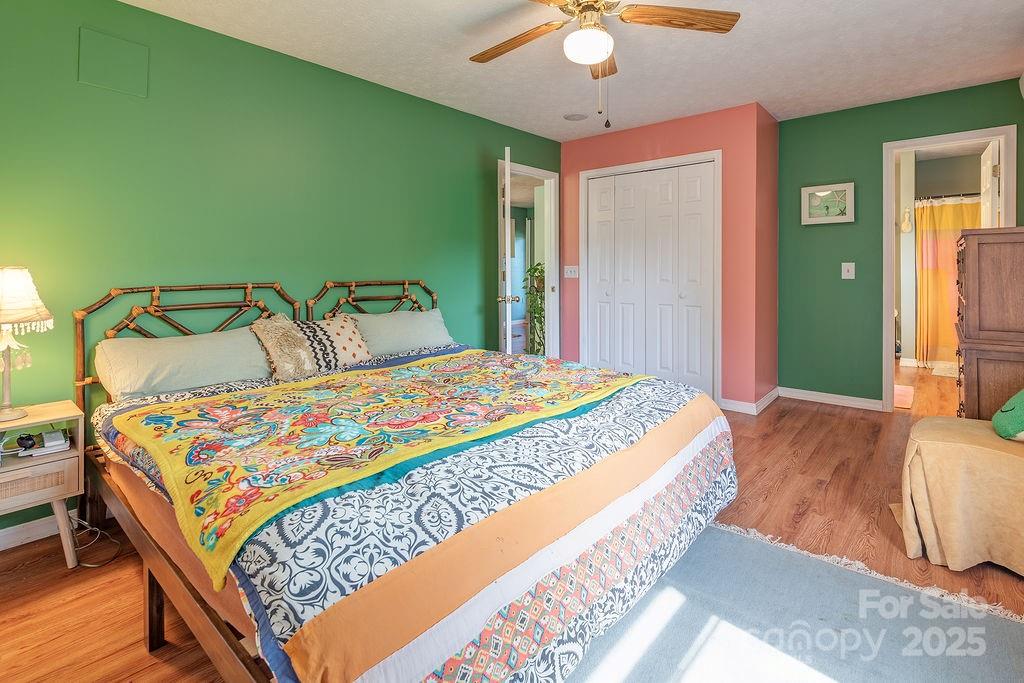 124 Beaverdam Loop Road Candler, NC 28715 - Photo 16 of 31 a bedroom with a bed and a chandelier