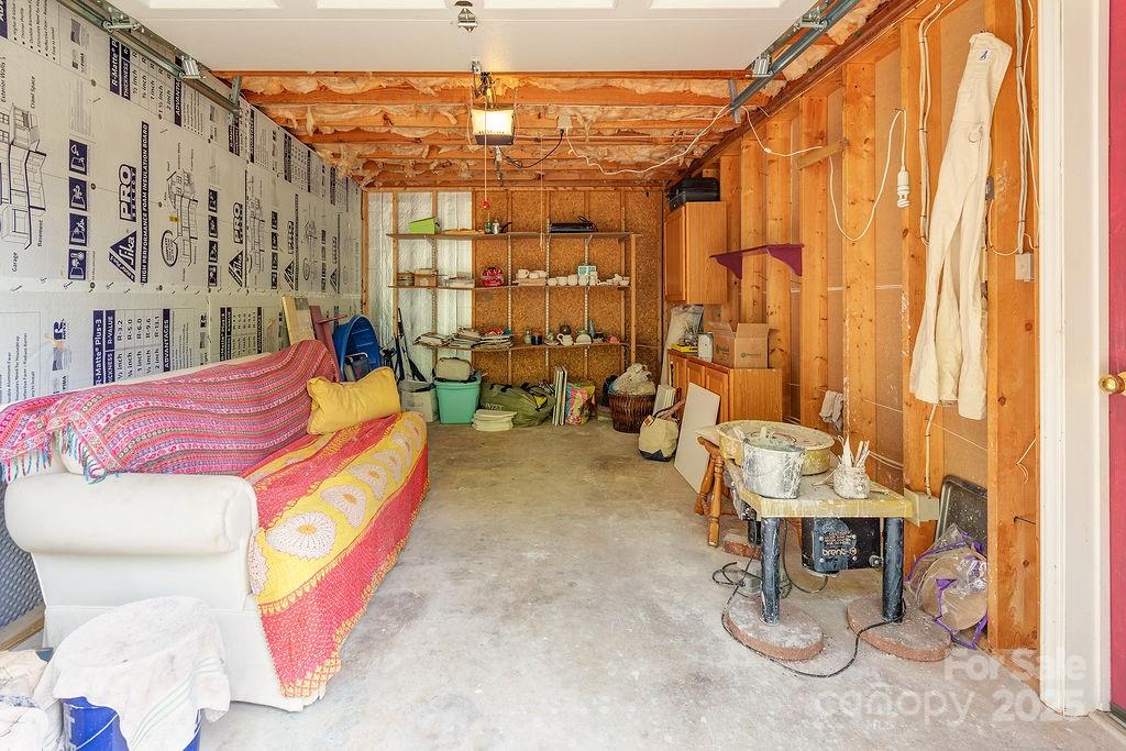 124 Beaverdam Loop Road Candler, NC 28715 - Photo 23 of 31 a bed room with a bed and a chandelier