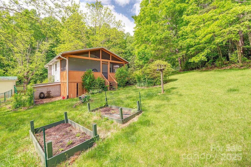124 Beaverdam Loop Road Candler, NC 28715 - Photo 25 of 31 a view of a backyard with table and chairs under an umbrella