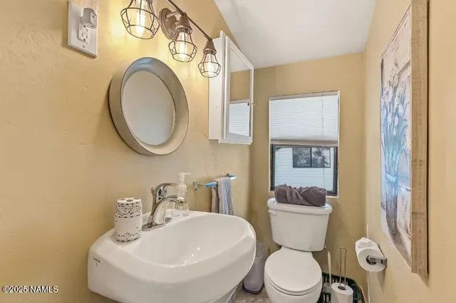 a bathroom with a toilet sink and a mirror