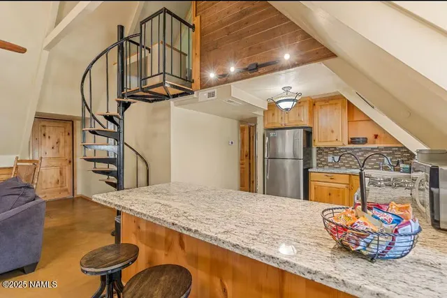 a kitchen with stainless steel appliances granite countertop a sink a stove and a wooden floors