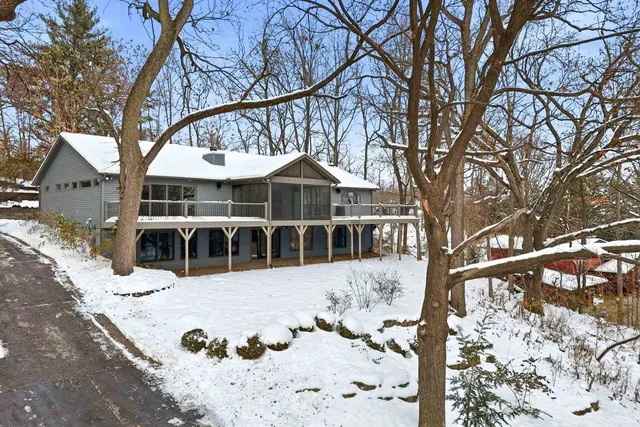 a view of a house with a yard covered in snow