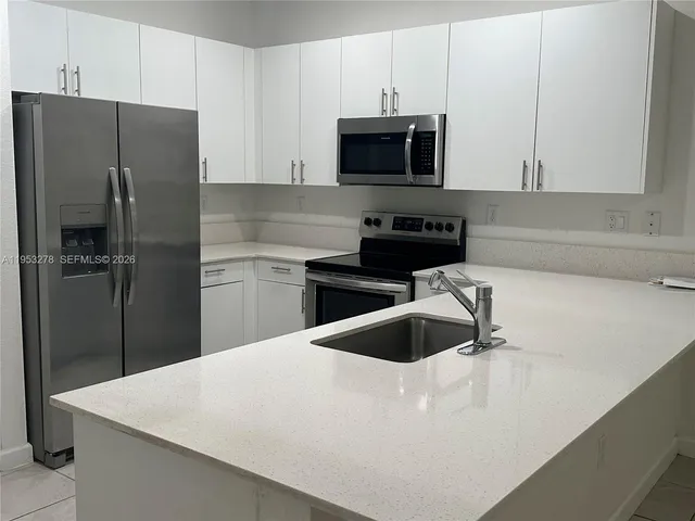 a room with a washing machine and cabinets