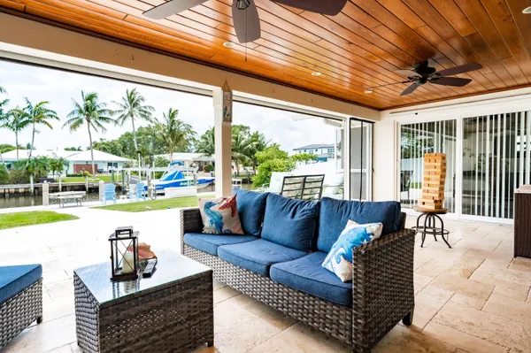 a living room with patio furniture and a floor to ceiling window