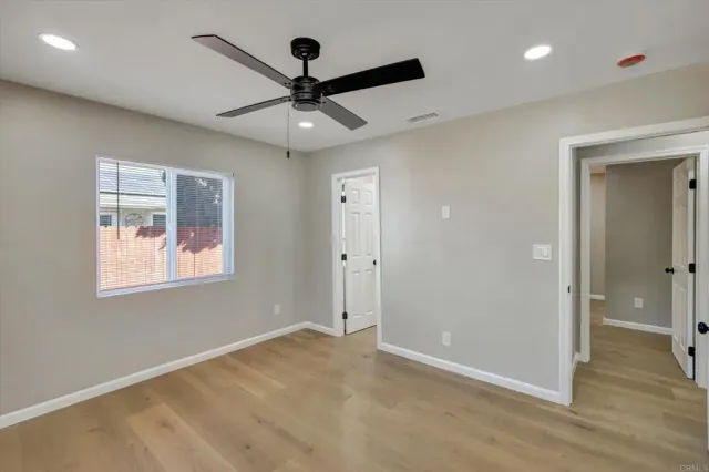 an empty room with a window and a fan