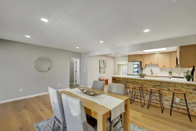 a dining room with wooden floor and a chandelier