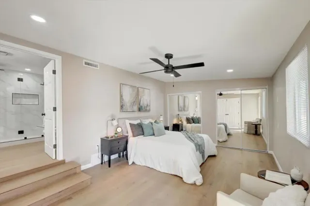 a spacious bedroom with a bed and a chandelier