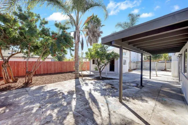a view of a house with backyard and sitting area