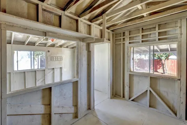 a white house that has a small yard and large trees