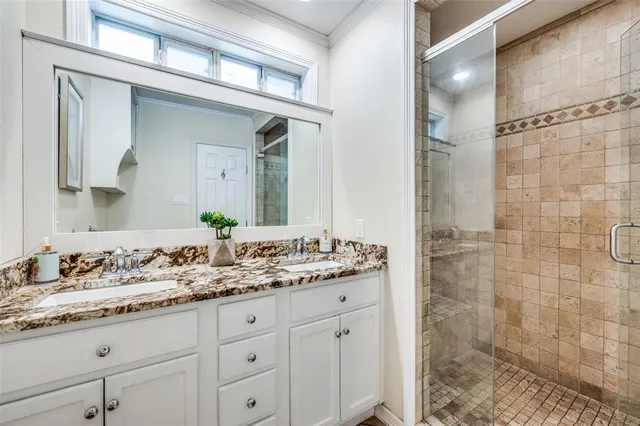 a bathroom with a granite countertop sink a mirror and a shower