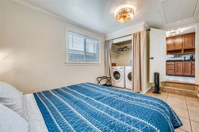 a bedroom with a bed and a flat tv screen on dresser