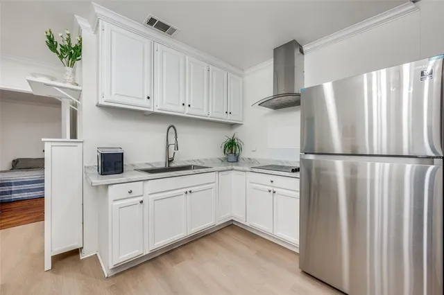 a kitchen with white cabinets and refrigerator