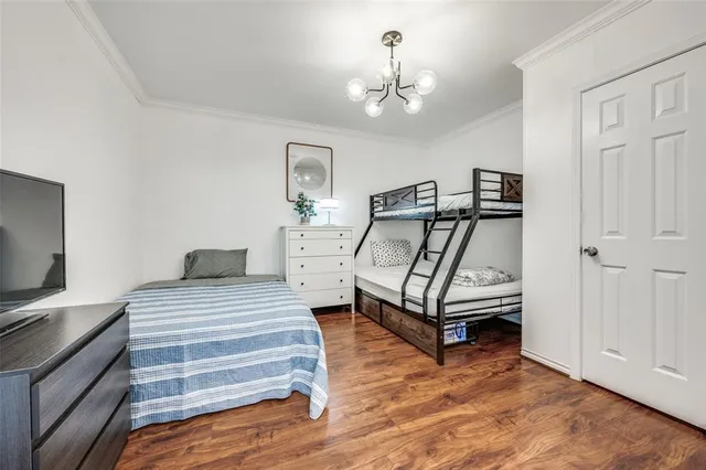 a bedroom with a bed and a flat tv screen on the dresser