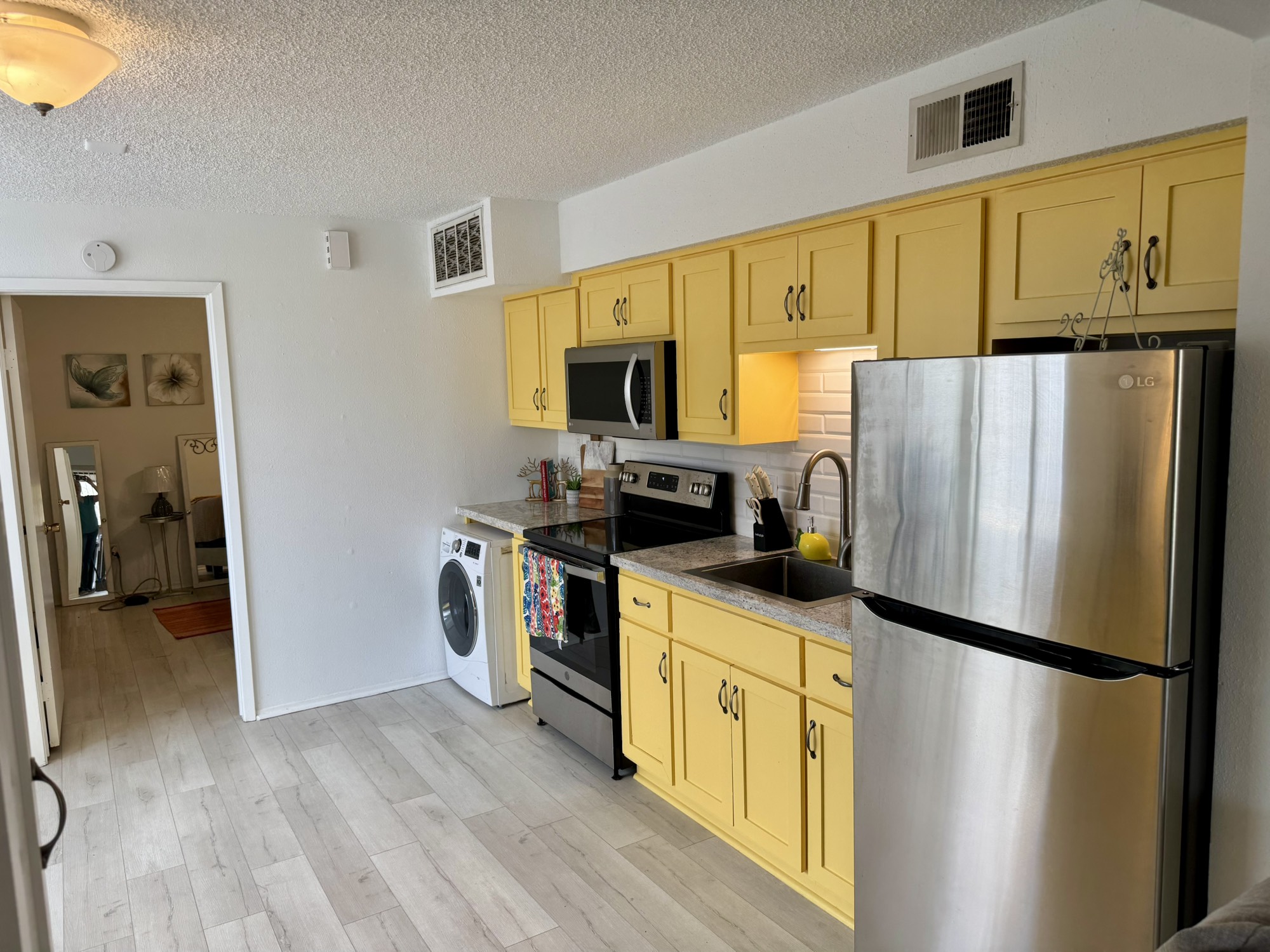 12900 Walden Road, Unit 820 Montgomery, TX 77356 - Photo 2 of 14 a kitchen with stainless steel appliances a refrigerator stove and microwave