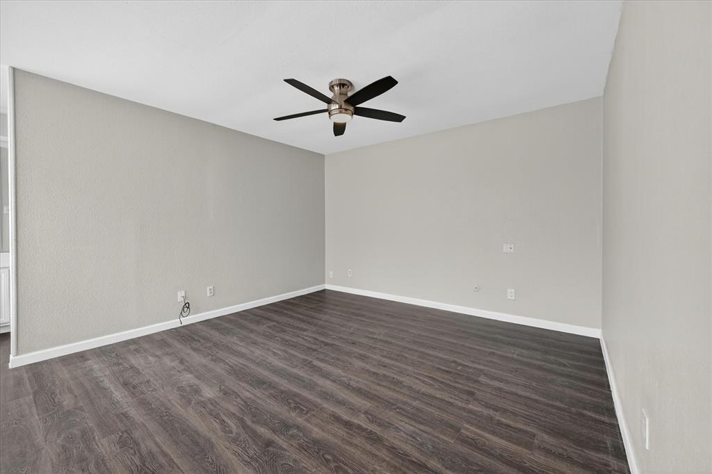 9809 Matchpoint Place Dallas, TX 75243 - Photo 16 of 21 Upstairs Spacious room featuring wood-finish flooring, light neutral wall tones, white baseboards, and a ceiling fan with light fixture