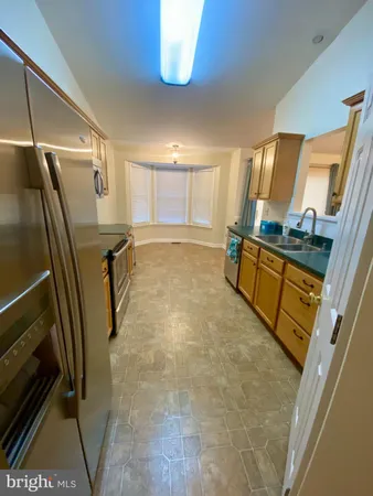 a kitchen with granite countertop a refrigerator stove and microwave