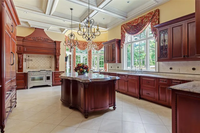 a large kitchen with a large counter space a sink stainless steel appliances and cabinets