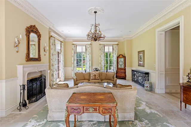 a living room with fireplace furniture and a chandelier