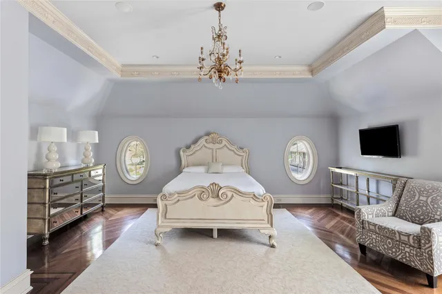 a living room with couch a dining table a mirror and a clock on the wall