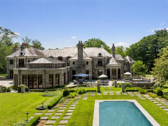 a front view of a house with swimming pool having outdoor seating