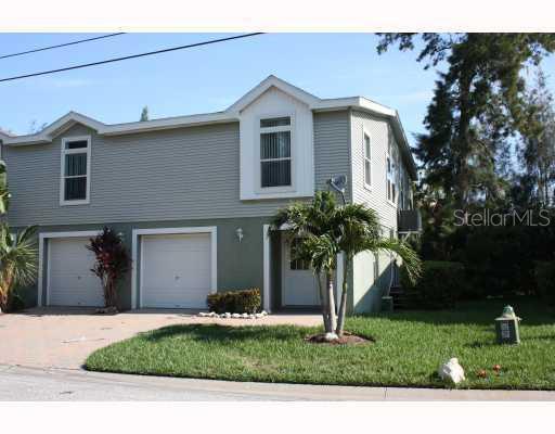 7734 Sailwinds Pass Port Richey, FL 34668 - Photo 1 of 1 a front view of a house with a yard and garage