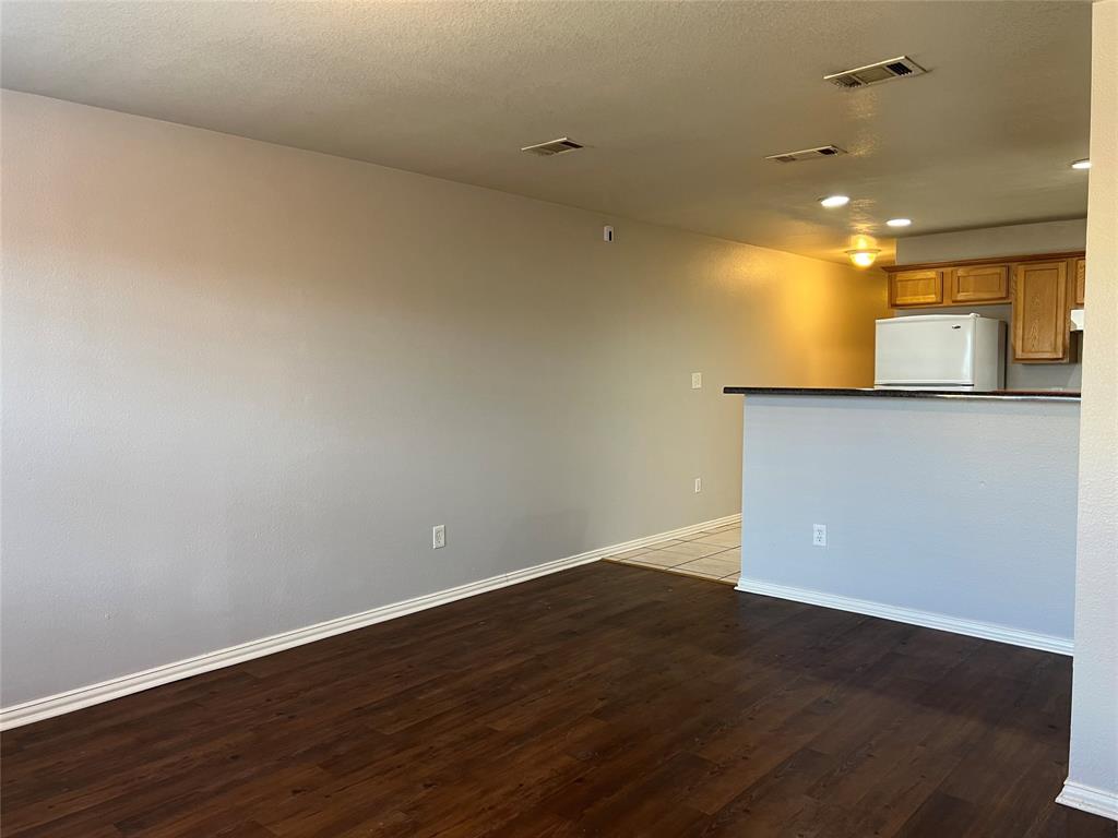 4027 Preferred Place Dallas, TX 75237 - Photo 12 of 27 an empty room with wooden floor and windows