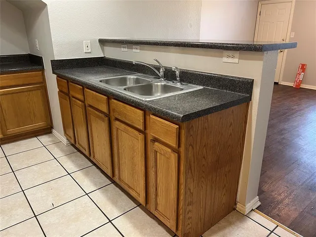 a kitchen with stainless steel appliances granite countertop a sink and a refrigerator