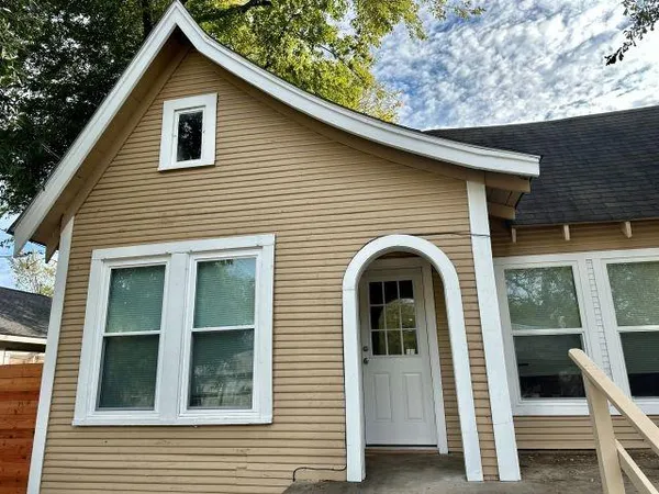 a view of a house with large windows and a small yard