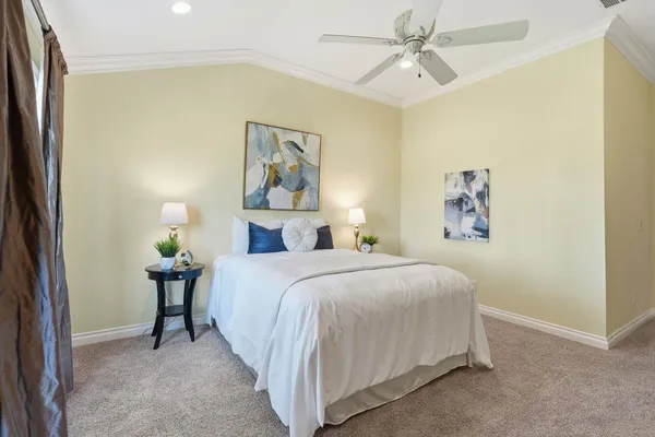 a bedroom with a bed and painting on the wall