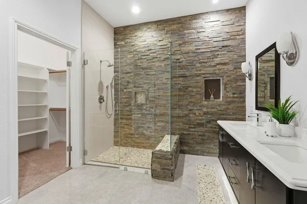 a bathroom with a granite countertop sink a toilet a mirror and shower