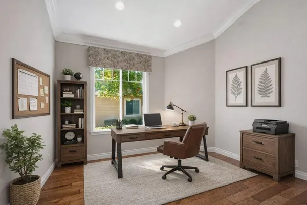 a view of a workspace with furniture and a window