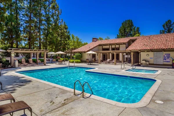 a view of a house with pool and chairs