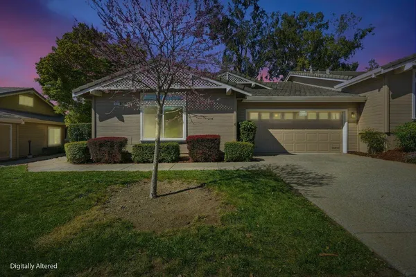 a view of a house with backyard and a tree