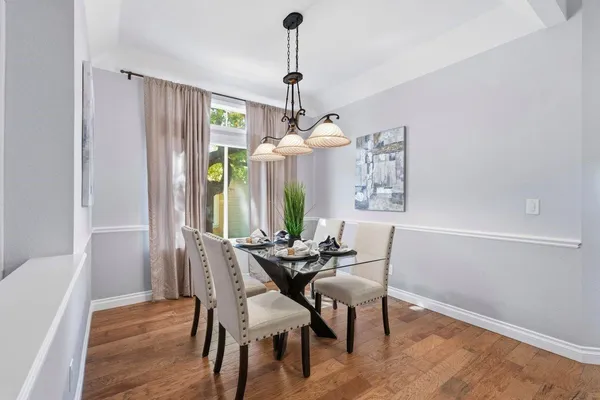 a dining room with furniture a chandelier and wooden floor
