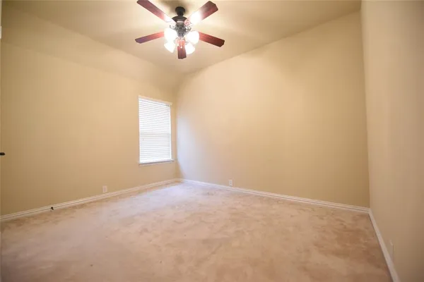 an empty room with a window and a fan