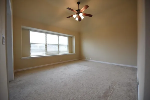 an empty room with windows and fan